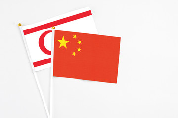 China and Northern Cyprus stick flags on white background. High quality fabric, miniature national flag. Peaceful global concept.White floor for copy space.
