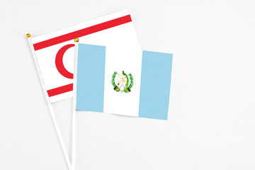 Guatemala and Northern Cyprus stick flags on white background. High quality fabric, miniature national flag. Peaceful global concept.White floor for copy space.