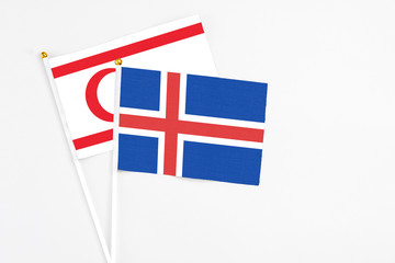 Obraz premium Iceland and Northern Cyprus stick flags on white background. High quality fabric, miniature national flag. Peaceful global concept.White floor for copy space.