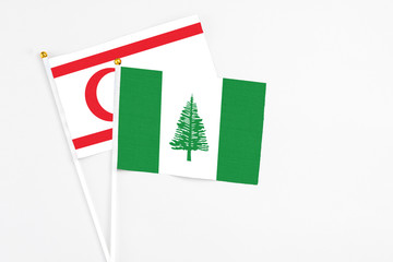 Norfolk Island and Northern Cyprus stick flags on white background. High quality fabric, miniature national flag. Peaceful global concept.White floor for copy space.