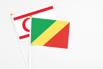 Republic Of The Congo and Northern Cyprus stick flags on white background. High quality fabric, miniature national flag. Peaceful global concept.White floor for copy space.