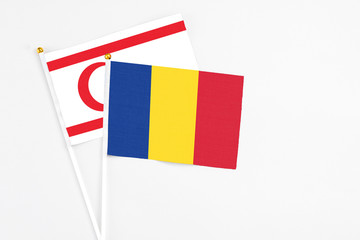 Romania and Northern Cyprus stick flags on white background. High quality fabric, miniature national flag. Peaceful global concept.White floor for copy space.