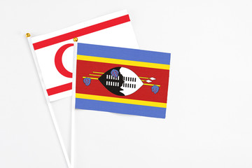 Swaziland and Northern Cyprus stick flags on white background. High quality fabric, miniature national flag. Peaceful global concept.White floor for copy space.