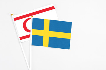 Sweden and Northern Cyprus stick flags on white background. High quality fabric, miniature national flag. Peaceful global concept.White floor for copy space.