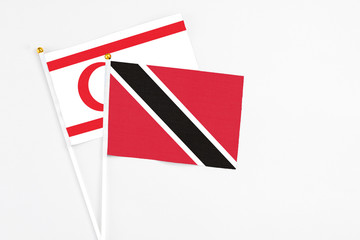 Trinidad And Tobago and Northern Cyprus stick flags on white background. High quality fabric, miniature national flag. Peaceful global concept.White floor for copy space.
