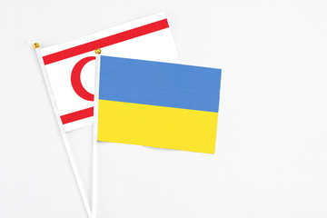Ukraine and Northern Cyprus stick flags on white background. High quality fabric, miniature national flag. Peaceful global concept.White floor for copy space.
