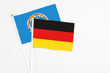 Germany and Northern Mariana Islands stick flags on white background. High quality fabric, miniature national flag. Peaceful global concept.White floor for copy space.