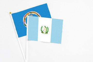 Guatemala and Northern Mariana Islands stick flags on white background. High quality fabric, miniature national flag. Peaceful global concept.White floor for copy space.