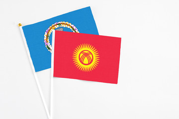 Kyrgyzstan and Northern Mariana Islands stick flags on white background. High quality fabric, miniature national flag. Peaceful global concept.White floor for copy space.