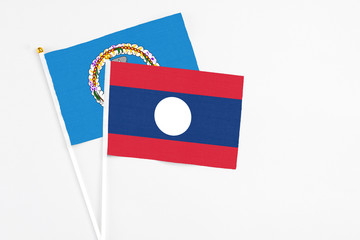 Laos and Northern Mariana Islands stick flags on white background. High quality fabric, miniature national flag. Peaceful global concept.White floor for copy space.