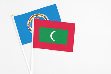 Maldives and Northern Mariana Islands stick flags on white background. High quality fabric, miniature national flag. Peaceful global concept.White floor for copy space.