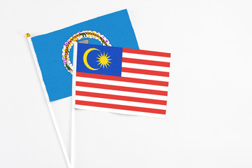 Malaysia and Northern Mariana Islands stick flags on white background. High quality fabric, miniature national flag. Peaceful global concept.White floor for copy space.