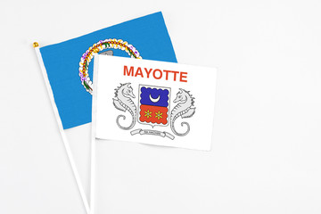 Mayotte and Northern Mariana Islands stick flags on white background. High quality fabric, miniature national flag. Peaceful global concept.White floor for copy space.