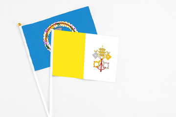 Vatican City and Northern Mariana Islands stick flags on white background. High quality fabric, miniature national flag. Peaceful global concept.White floor for copy space.