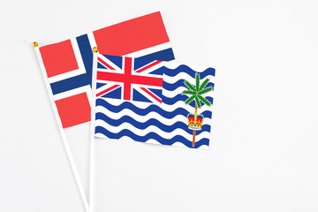 Fototapeta premium British Indian Ocean Territory and Norway stick flags on white background. High quality fabric, miniature national flag. Peaceful global concept.White floor for copy space.