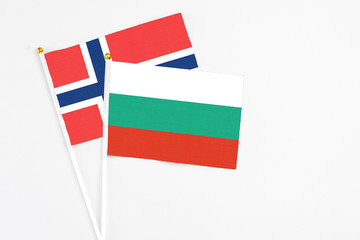 Bulgaria and Norway stick flags on white background. High quality fabric, miniature national flag. Peaceful global concept.White floor for copy space.