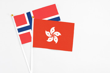 Hong Kong and Norway stick flags on white background. High quality fabric, miniature national flag. Peaceful global concept.White floor for copy space.