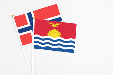 Kiribati and Norway stick flags on white background. High quality fabric, miniature national flag. Peaceful global concept.White floor for copy space.