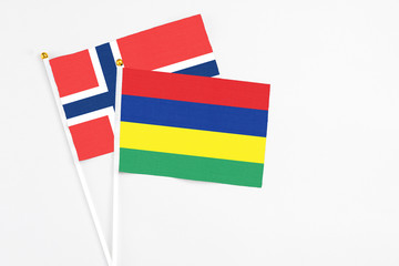 Mauritius and Norway stick flags on white background. High quality fabric, miniature national flag. Peaceful global concept.White floor for copy space.