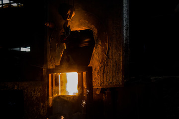Fototapeta na wymiar metal casting process with red high temperature fire in metal part factory