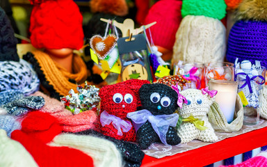 Cat toys among other knitted warm clothes on stalls at Christmas market in Riga of Latvia winter. Street Xmas and holiday fair in European city or town. Advent Decoration with Crafts Items on Bazaar