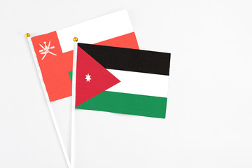 Jordan and Oman stick flags on white background. High quality fabric, miniature national flag. Peaceful global concept.White floor for copy space.