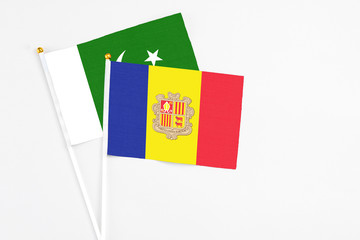 Andorra and Pakistan stick flags on white background. High quality fabric, miniature national flag. Peaceful global concept.White floor for copy space.