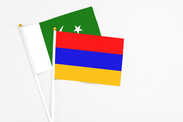 Armenia and Pakistan stick flags on white background. High quality fabric, miniature national flag. Peaceful global concept.White floor for copy space.