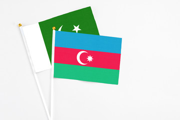 Azerbaijan and Pakistan stick flags on white background. High quality fabric, miniature national flag. Peaceful global concept.White floor for copy space.