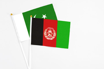 Afghanistan and Pakistan stick flags on white background. High quality fabric, miniature national flag. Peaceful global concept.White floor for copy space.