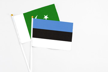 Estonia and Pakistan stick flags on white background. High quality fabric, miniature national flag. Peaceful global concept.White floor for copy space.