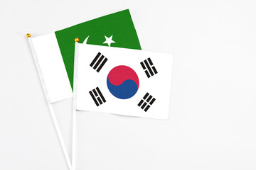 South Korea and Pakistan stick flags on white background. High quality fabric, miniature national flag. Peaceful global concept.White floor for copy space.