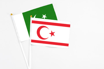 Northern Cyprus and Pakistan stick flags on white background. High quality fabric, miniature national flag. Peaceful global concept.White floor for copy space.