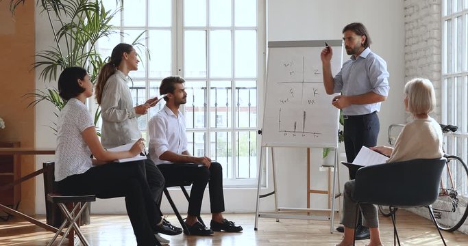 Businessman teaching multiethnic staff presenting corporate strategy on whiteboard