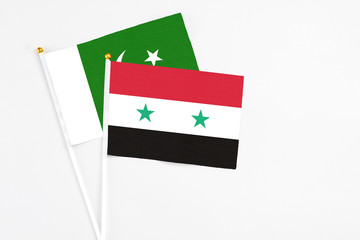 Syria and Pakistan stick flags on white background. High quality fabric, miniature national flag. Peaceful global concept.White floor for copy space.