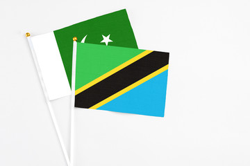 Tanzania and Pakistan stick flags on white background. High quality fabric, miniature national flag. Peaceful global concept.White floor for copy space.