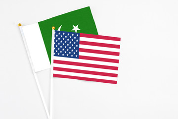 United States and Pakistan stick flags on white background. High quality fabric, miniature national flag. Peaceful global concept.White floor for copy space.