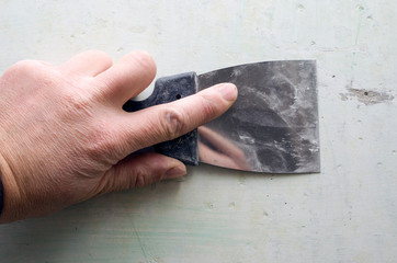 Hand with putty knife repair wall, Hand with a spatula, spatula with spackle paste structure,...