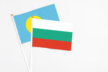 Bulgaria and Palau stick flags on white background. High quality fabric, miniature national flag. Peaceful global concept.White floor for copy space.