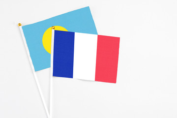 France and Palau stick flags on white background. High quality fabric, miniature national flag. Peaceful global concept.White floor for copy space.