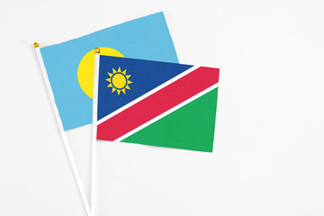 Namibia and Palau stick flags on white background. High quality fabric, miniature national flag. Peaceful global concept.White floor for copy space.