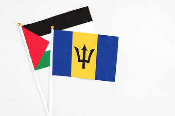 Barbados and Palestine stick flags on white background. High quality fabric, miniature national flag. Peaceful global concept.White floor for copy space.