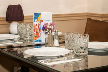 Decoration of one of the tables in restaurant in coffee beige tone. Menu map prepared for celebrating New Year.