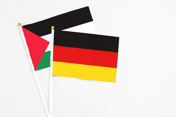 Germany and Palestine stick flags on white background. High quality fabric, miniature national flag. Peaceful global concept.White floor for copy space.