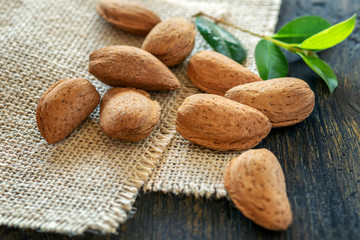 Some fresh whole almonds on the wooden table, healthy food concept.
