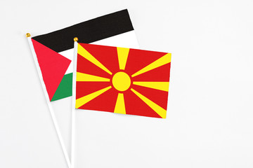 Macedonia and Palestine stick flags on white background. High quality fabric, miniature national flag. Peaceful global concept.White floor for copy space.