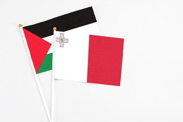 Malta and Palestine stick flags on white background. High quality fabric, miniature national flag....