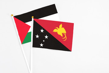 Papua New Guinea and Palestine stick flags on white background. High quality fabric, miniature national flag. Peaceful global concept.White floor for copy space.