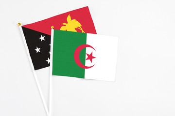 Algeria and Papua New Guinea stick flags on white background. High quality fabric, miniature...