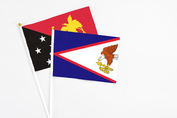 American Samoa and Papua New Guinea stick flags on white background. High quality fabric, miniature...